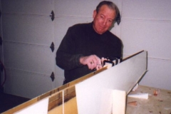 Made jig to hold horizontal stabilizer verticle. Filled hinge holes with clay, Q-cell radiused the shear web and applied 2 layer laminates to upper and lower horizontal stabilizer panels and shear web. Cut 14 strips of BID for application to the leading edge of the horizontal stabilizer. Repaired bubble in rear shear laminate (photo)