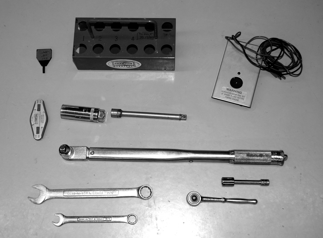 Spark plug tray, adjusting tool, gap gage, spark plug socket and extension, magneto timer, torque wrench, combination wrenches, ratchet, socket and extension